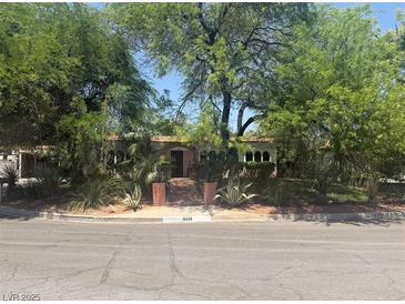 Charming single-story home featuring lush landscaping, classic architecture, and inviting curb appeal at 4444 Denia Cir, Las Vegas, NV 89108