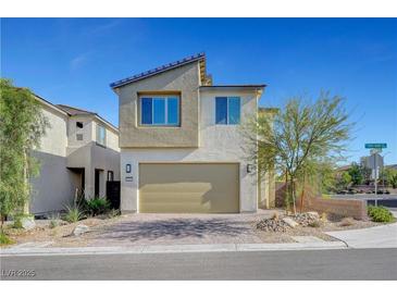 Modern two-story home with a two-car garage, desert landscaping, and a brick driveway on a sunny day at 7853 Bethel Heights Ln, Las Vegas, NV 89113