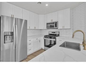 Modern kitchen featuring stainless steel appliances, white cabinets, and quartz countertops at 8416 Kawala Dr, Las Vegas, NV 89128