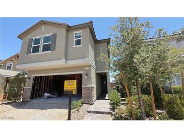 Charming two-story home featuring stone accents, an unfinished garage, and professionally landscaped front yard at 9136 Eagle Ford St, Las Vegas, NV 89113