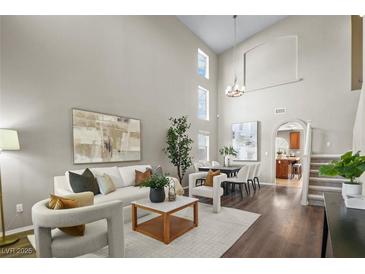 Bright and airy living room with high ceilings, modern furnishings, and dark wood flooring at 445 Colorful Rain Ave, North Las Vegas, NV 89031