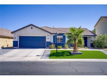 Charming single-story home with blue garage door, palm tree, and artificial turf lawn at 925 Mandolin Way, North Las Vegas, NV 89032
