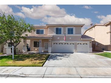 Inviting two-story home features a three-car garage, manicured lawn, and desert landscaping at 9709 Casper Peak Ct, Las Vegas, NV 89117