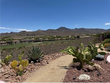 Landscaped backyard featuring desert plants, gravel pathways and views of mountains and the golf course at 18 Brookridge Dr, Henderson, NV 89052