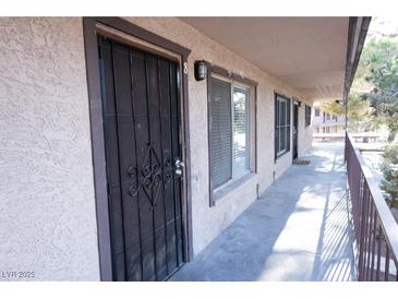 Apartment front door with security gate and covered walkway at 605 S Royal Crest Cir # 8, Las Vegas, NV 89169
