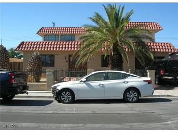 Charming two-story home with a red tile roof, desert landscaping, and secure gated yard at 6325 Burgundy Way, Las Vegas, NV 89107