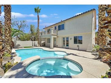 Resort-style backyard featuring a sparkling pool, spa, and lush tropical landscaping, perfect for relaxing and entertaining at 1557 Sabatini Dr, Henderson, NV 89052