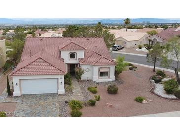 Charming single-story home featuring a red tile roof, stucco siding, desert landscaping, and a two-car garage at 2524 Banora Point Dr, Las Vegas, NV 89134