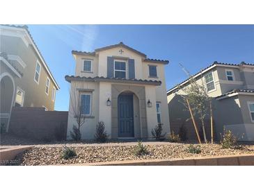 Charming two-story home with a blue door, symmetrical design, and desert landscaping at 2713 Abrantes Pl, Henderson, NV 89044