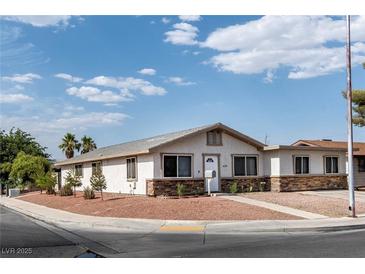 Charming single-story home featuring a landscaped front yard and a stone accent base at 4676 E Alexander Rd, Las Vegas, NV 89115