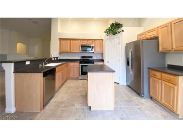 Well-lit kitchen with stainless steel appliances, spacious countertops and island, perfect for cooking and entertaining at 4717 Mohawk River Ave, North Las Vegas, NV 89031