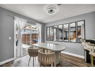 Bright dining room featuring wood floors, modern lighting, and sliding glass doors to the backyard at 5024 Starfinder Ave, Las Vegas, NV 89108