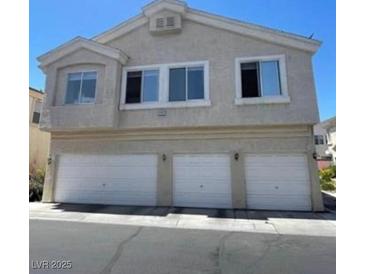 Three-story townhome featuring a stucco exterior and a three-car garage at 5969 High Steed St # 101, Henderson, NV 89011