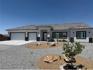 Charming single-story home with a gravel yard, tiled roof, and a two-car garage at 790 Fort Churchill Rd, Pahrump, NV 89060