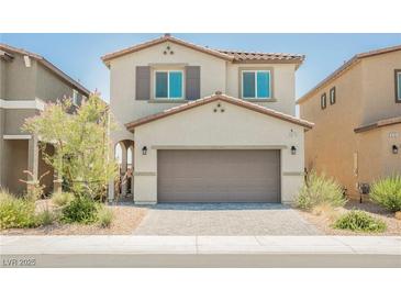 Two-story home featuring a two-car garage, desert landscaping, and a light beige exterior at 8278 Palladium St, Las Vegas, NV 89113