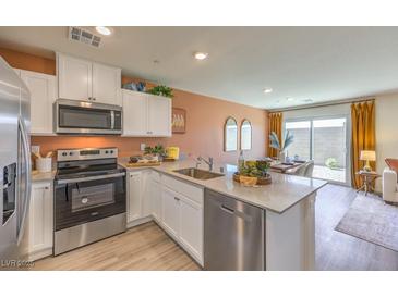 Modern kitchen features stainless steel appliances, white cabinetry, and granite countertops at 10982 Rollingford Ave # Lot 7, Las Vegas, NV 89166