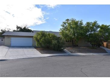 Charming single-story home with a well-manicured front yard, mature trees, and a two-car garage at 3633 Monte Verde St, Las Vegas, NV 89121