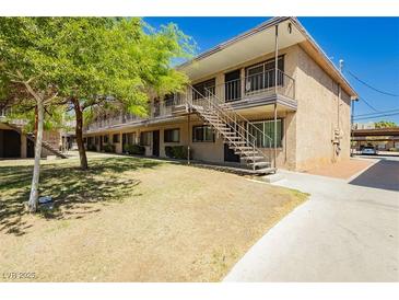 Apartment building featuring a stucco exterior, stair access, and landscaping at 3719 Hazelwood St # 16, Las Vegas, NV 89119