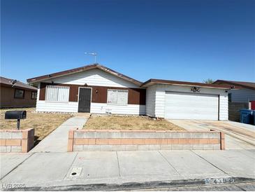 Traditional single-story home featuring a two-car garage and desert landscaping in front at 4303 Paramount St, Las Vegas, NV 89115