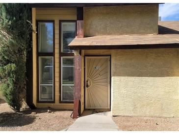 A townhome with a unique security door, large windows, and xeriscape at 513 Kristin Ln, Henderson, NV 89011