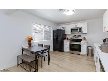 Bright kitchen with white cabinets, stainless steel appliances, and a dining area at 335 W Basic Rd, Henderson, NV 89015