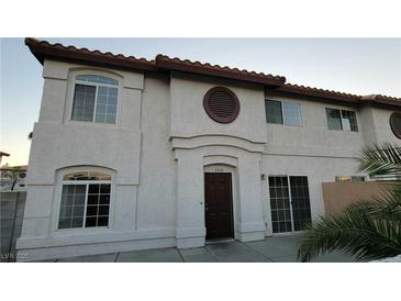 Inviting townhouse featuring a solid wood front door and an arched window above for unique curb appeal at 3930 Starfield Ln, Las Vegas, NV 89147