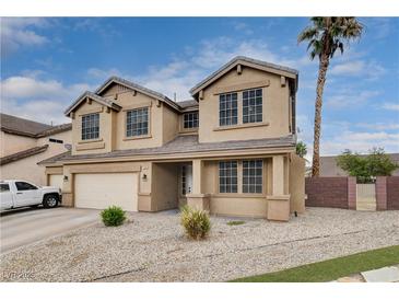 Inviting two-story home featuring a well-kept lawn, desert landscaping, and neutral color palette at 108 Parker Ranch Dr, Henderson, NV 89012