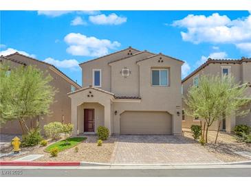 Two-story home featuring neutral stucco, tiled roof, manicured lawn, and paver driveway at 9947 Tucket Point Ct, Las Vegas, NV 89178