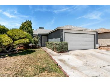 Charming single story home featuring a 2 car garage, well-manicured bushes, and desert landscaping at 2093 Seahurst Dr, Las Vegas, NV 89142