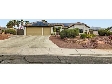 Inviting home features a two-car garage, desert landscaping, and solar panels on the roof at 7404 Wittig Ave, Las Vegas, NV 89131