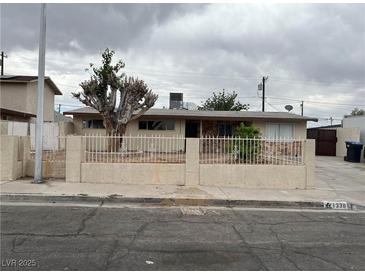 Charming single-story home with a well-maintained front yard and a decorative fence at 1338 Smoke Tree Ave, Las Vegas, NV 89108