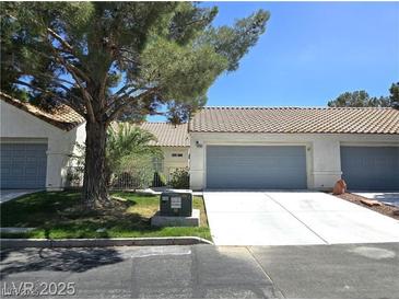 Inviting single story home featuring a charming desert landscape, covered front porch, and an attached two-car garage at 2253 Van Gogh Dr, Henderson, NV 89074