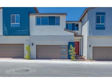 Modern townhome featuring a two-car garage, contemporary design, and a red front door at 2523 Campaldo St, Henderson, NV 89044