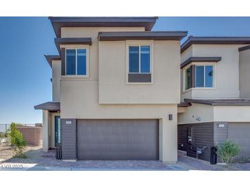 Contemporary home featuring a two-car garage and neutral stucco exterior with dark brown trim at 860 Echelon St, Las Vegas, NV 89138
