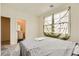 Bedroom featuring neutral walls, carpet, and a bright window with a view to the bathroom area at 2705 Cava Tirreni St, Henderson, NV 89044