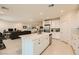 Open kitchen with white cabinets, island, stainless steel appliances, and adjacent living area at 2705 Cava Tirreni St, Henderson, NV 89044