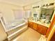 Bright bathroom featuring a large soaking tub, tiled platform and double sink vanity at 2089 Avalon Dr, Laughlin, NV 89029