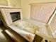 Bathroom with a large tiled jacuzzi bathtub under a window with window blinds at 2089 Avalon Dr, Laughlin, NV 89029