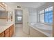 Bright bathroom with a soaking tub and an open doorway to bedroom at 6990 W Richmar Ave, Las Vegas, NV 89178