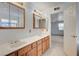 Bathroom featuring double vanity, wood cabinets and framed mirror at 6990 W Richmar Ave, Las Vegas, NV 89178