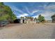 Detached storage units, an open garage, and mature trees fill this property at 6990 W Richmar Ave, Las Vegas, NV 89178