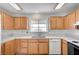 This bright kitchen area features wood cabinetry, white appliances, and marble counters at 6990 W Richmar Ave, Las Vegas, NV 89178