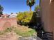 Landscaped backyard with mature trees and brick wall, providing privacy and shade at 6007 Turtle River Ave, Las Vegas, NV 89156