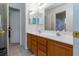 Well-lit bathroom with double sinks, oak cabinets, and a doorway to an adjoining room at 6007 Turtle River Ave, Las Vegas, NV 89156