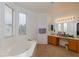 Bright bathroom featuring a large soaking tub with natural light from large windows at 6007 Turtle River Ave, Las Vegas, NV 89156