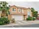 Charming two-story home featuring a terracotta-tiled roof, two-car garage, and lush landscaping with mature palm trees at 6007 Turtle River Ave, Las Vegas, NV 89156
