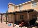 Exterior shot of a tan two-story home with a covered patio with outdoor seating at 6007 Turtle River Ave, Las Vegas, NV 89156