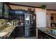 Well-lit kitchen featuring granite countertops, dark cabinetry, and stainless steel refrigerator at 6007 Turtle River Ave, Las Vegas, NV 89156