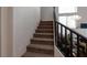 Carpeted staircase with black railing leading to the upper level of the home at 6007 Turtle River Ave, Las Vegas, NV 89156