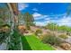 Inviting backyard featuring artificial turf, landscaped garden beds, and a tranquil outdoor setting at 79 Emerald Dunes Cir, Henderson, NV 89052